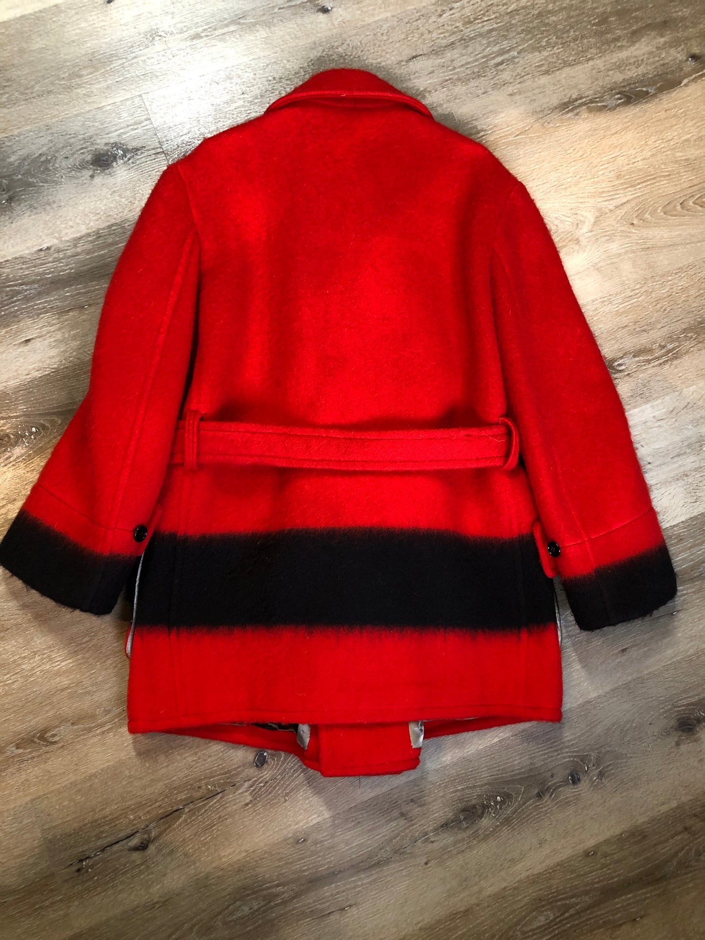 Kingspier Vintage - Genuine Hudson’s Bay Company point blanket coat in red with thick black stripe. The coat features flap pockets and hand warmer pockets, double breasted button closures and belt. Made in Canada. Mens size 48.