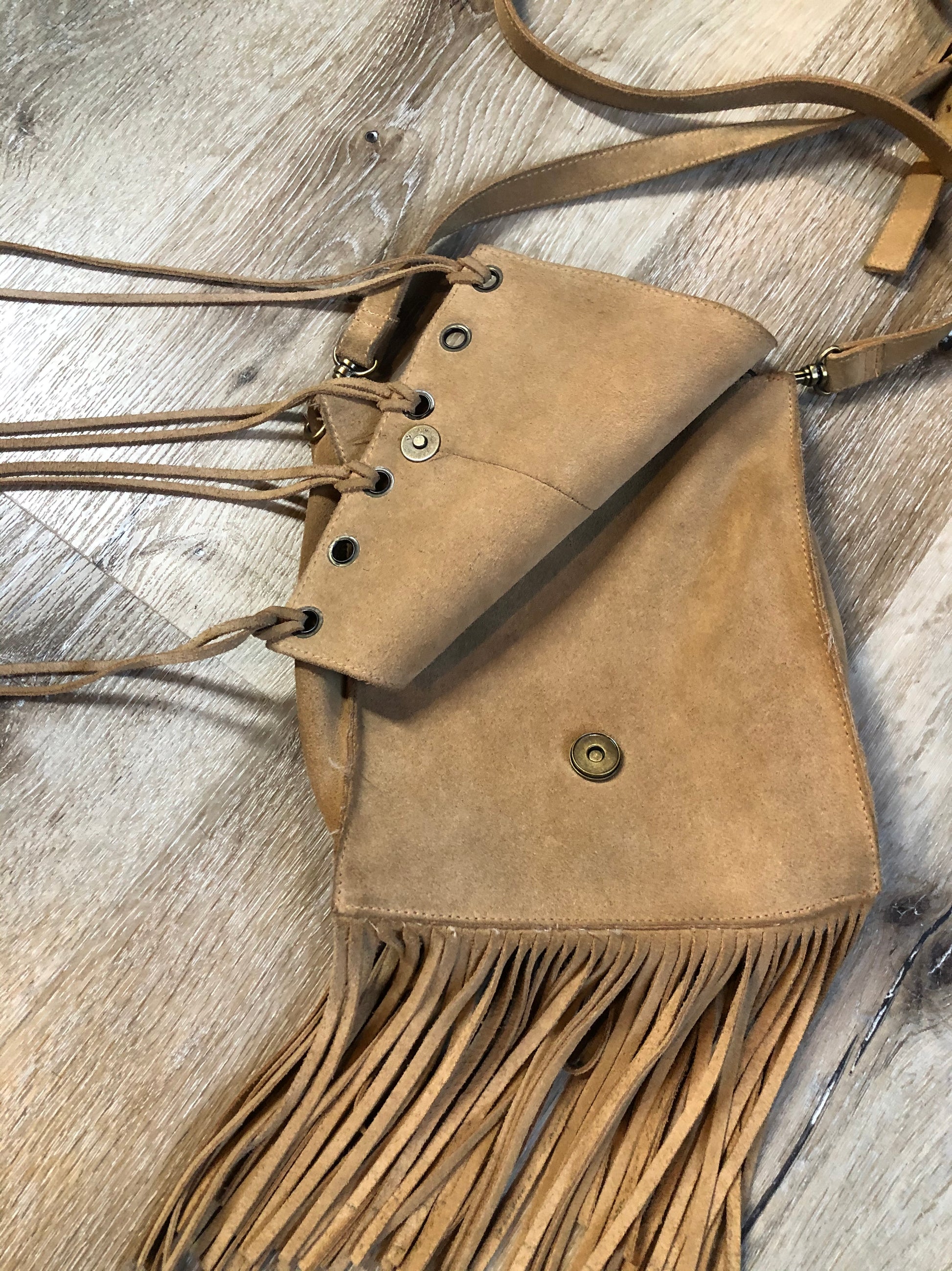 Kingspier Vintage - Suede crossbody bag with fringe, adjustable strap and snap closure.
