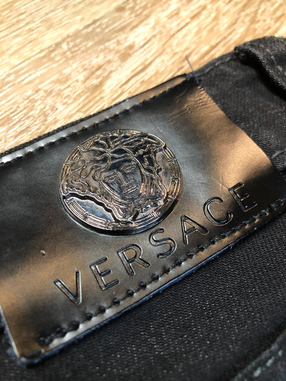 Kingspier Vintage - Versace black denim skinny jeans with metal Versace emblem on the back. Made in Italy. Size 27.