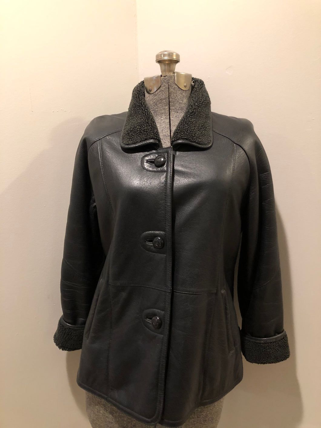 Kingspier Vintage - Contemporary black leather flight style jacket with synthetic wool pile lining , button closures and slash pockets.
