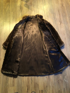 Kingspier Vintage - Vintage Vogue Furriers long fur coat circa 1970’s features leather button closures, two front pockets abd a brown satin lining.

Made in Nova Scotia, Canada.
Size Large.