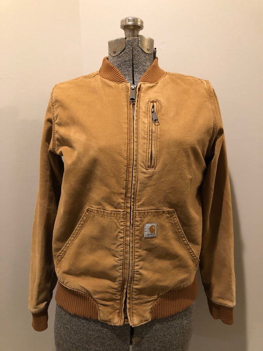 Kingspier Vintage - Carhartt tan bomber jacket with zipper closure, pockets, vertical zip pocket on chest, inside pocket and a lightweight lining. Women’s small.
