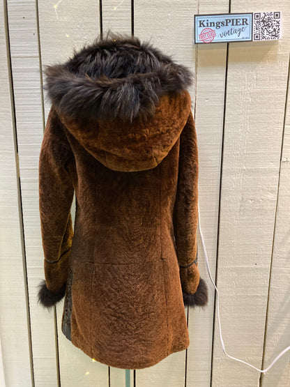 Kingspier Vintage - Vintage Weitral shearling coat with fur trimmed hood and cuffs, unique button closures, leather details with floral motif and two front pockets.

Size large.
Made in Russia.