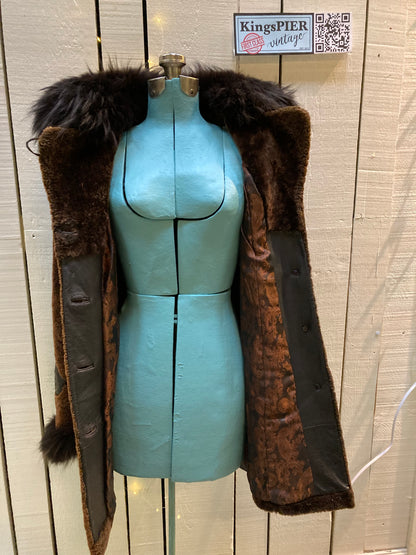 Kingspier Vintage - Vintage Weitral shearling coat with fur trimmed hood and cuffs, unique button closures, leather details with floral motif and two front pockets.

Size large.
Made in Russia.