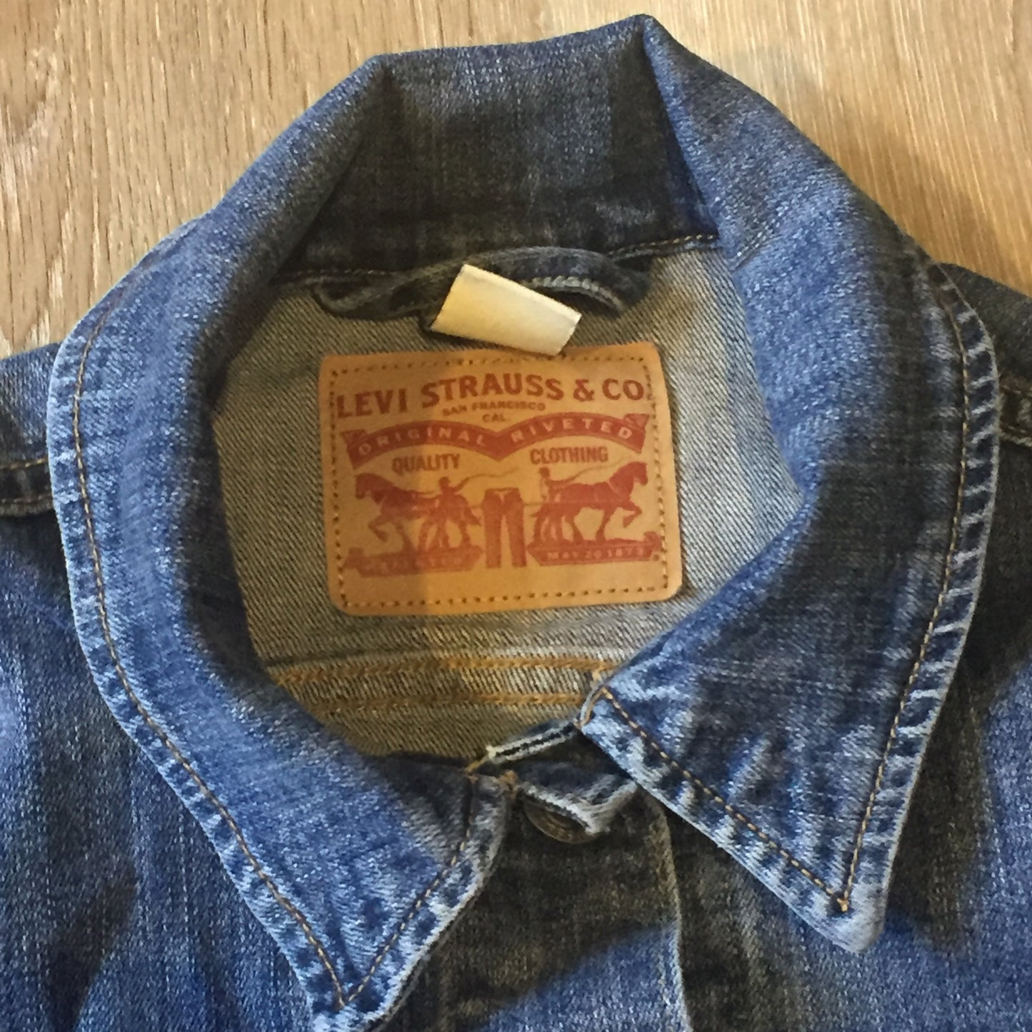 Kingspier Vintage - Levi’s medium wash denim trucker jacket with button closures, two flap pockets on the chest and two vertical pockets. Size medium.