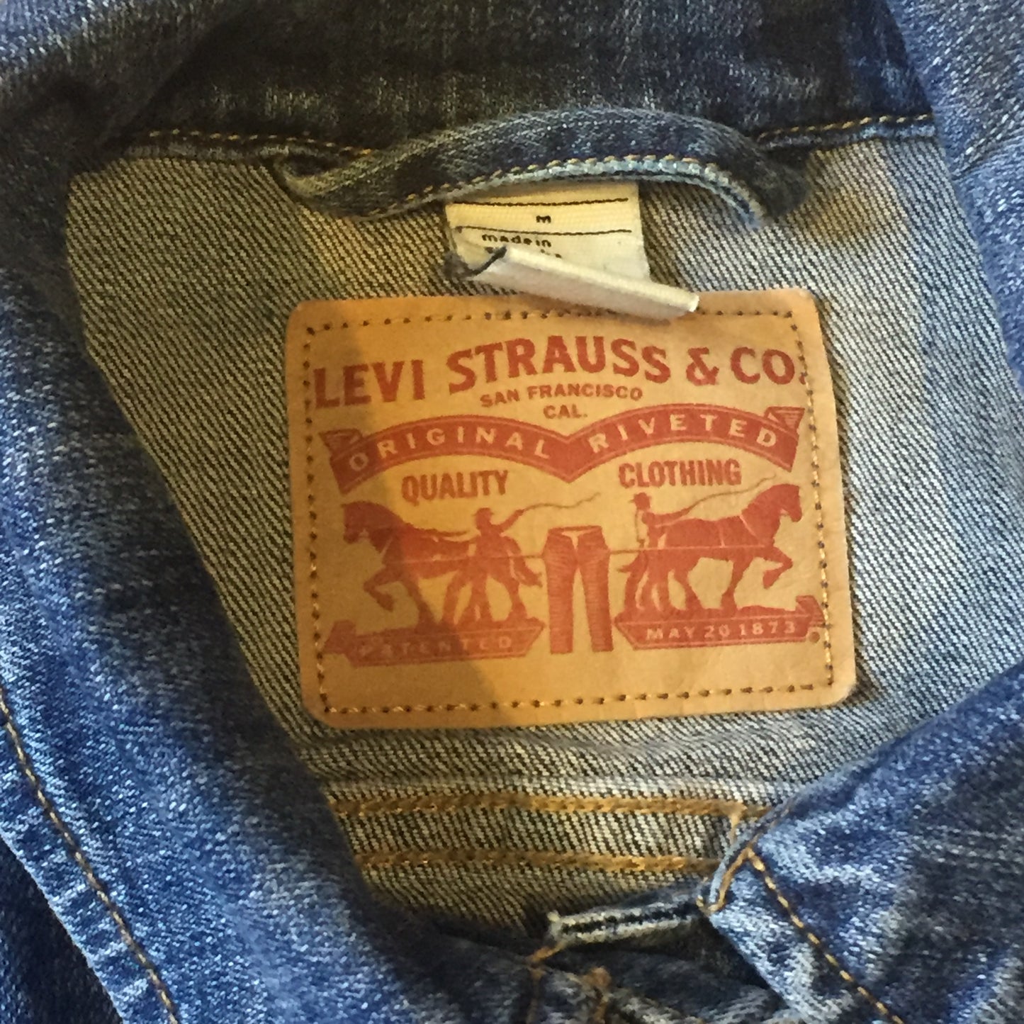 Kingspier Vintage - Levi’s medium wash denim trucker jacket with button closures, two flap pockets on the chest and two vertical pockets. Size medium.