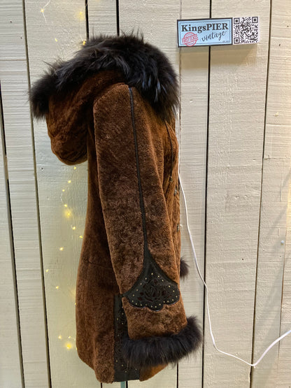 Kingspier Vintage - Vintage Weitral shearling coat with fur trimmed hood and cuffs, unique button closures, leather details with floral motif and two front pockets.

Size large.
Made in Russia.