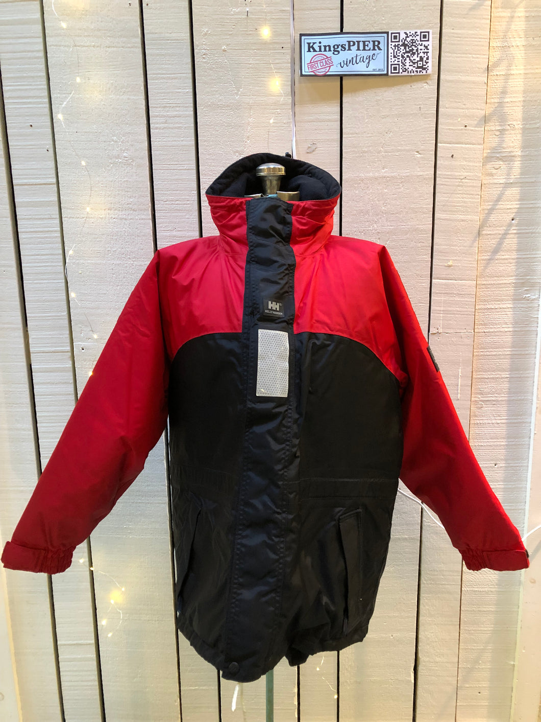 Kingspier Vintage - Helly Hansen red and black Soft Flex Echo Parka with Personal Flotation Device, Canadian Coast Guard approved.

Jacket features a packable hood, adjustable storm collar, zipper and snap closures, zip front pockets, waterproof shell, and PVC foam buoyant component.

Size Small.