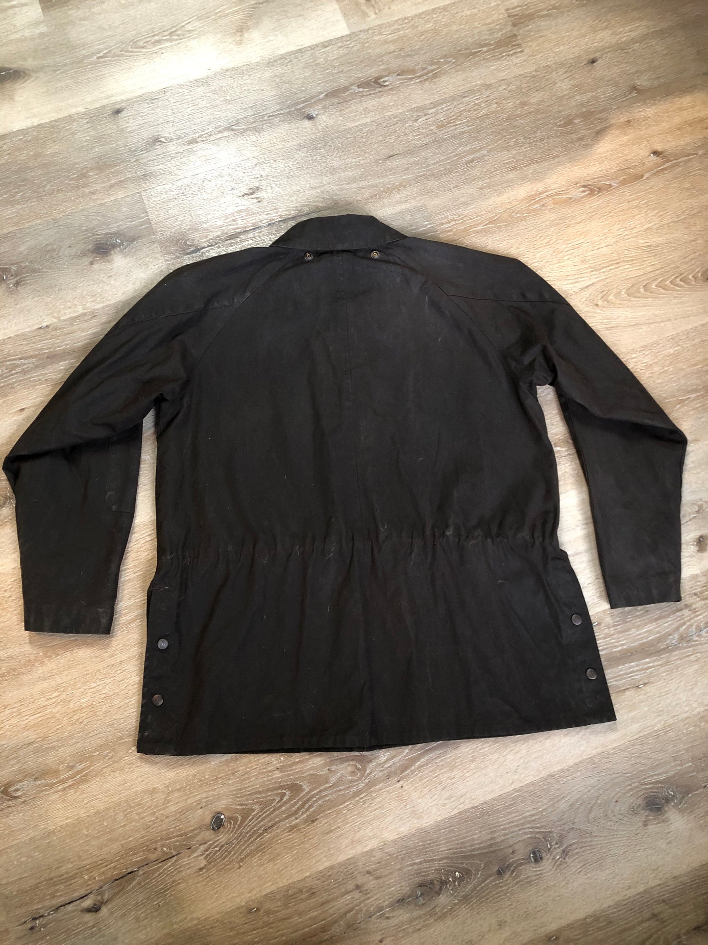 Kingspier Vintage - Outback Trading Co brown cotton oilskin rancher jacket with double snap closures, two snap flap pockets, one inside zip pocket, lightweight lining and drawstring at the waist. Fits large.
